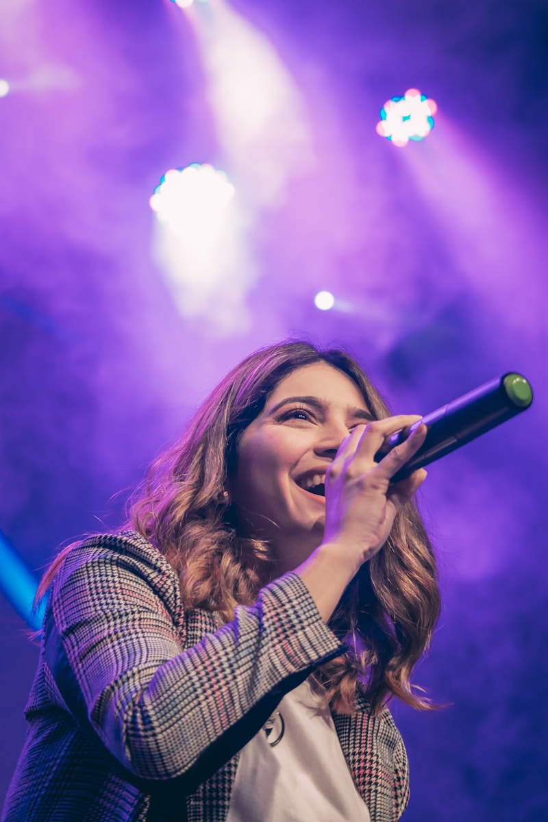 Artist performing on stage under colorful lights