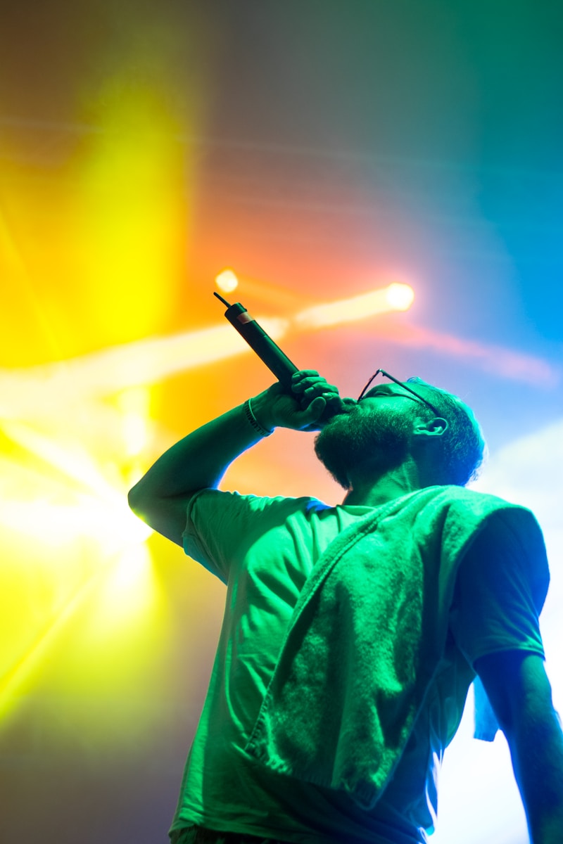 Artist singing on stage under purple lights